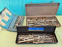 Three tool cases opened showing wrenches and sockets
