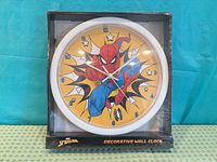 Front view of packaged Spider-Man wall clock showing design and shrink wrap