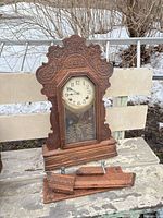 Front view of carved wood gingerbread clock with detached trim pieces
