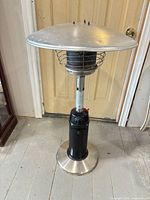 Full view of tabletop propane patio heater showing base, support column, burner, reflector