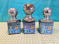 Three chrome hitch balls on packaging showing sizes and capacity