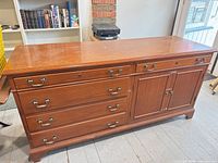 Full view of wood sideboard cabinet showing drawers, cupboard doors and hardware