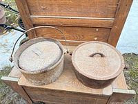 Two cast iron bean pots with lids, outer view