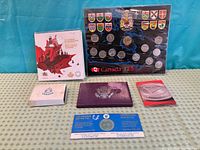 Six packaged Royal Canadian Mint coin and medal sets laid out on table