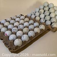 Two molded pulp trays filled with white used golf balls