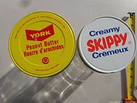 Top view of York and Skippy metal lids showing branding