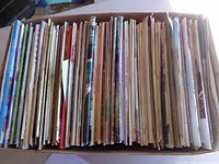 Box with numerous quilting magazines aligned vertically showing spines