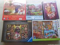 Five puzzle boxes front view showing titles and piece counts