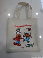 Full view of tote bag front showing graphics and handles