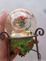 Full view of snow globe on stand showing base details