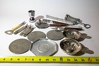 Full layout of all bar tools, coasters and tastevins with measuring tape for scale