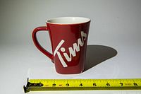 Front view of red Tim Hortons mug showing logo and scale