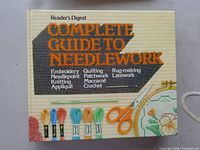 Front cover of the Reader's Digest Complete Guide to Needlework book showing title and craft tools imagery