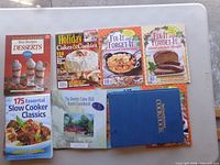 Eight cookbooks including desserts, holiday cakes, two Fix-It and Forget-It titles, slow cooker, apple cookbook and blue hardcover