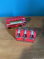 Welly red double-decker bus beside Coca-Cola mini lunch box closed