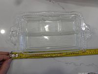 Rectangular three-section clear glass relish tray with tape measure for scale