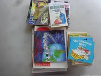 Stack of assorted humor books including Cows of Our Planet, Herman volume, The Chipmunk Story and additional small paperbacks