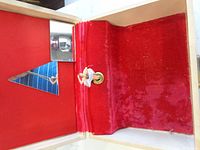 Interior of wooden jewellery box showing red velvet lining, mirror and broken ballerina mount