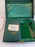 Open Harrington jewelry box showing interior lining, paper tag, and key