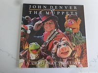 Front cover of the vinyl LP sleeve featuring John Denver and several Muppets characters
