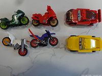All six LEGO vehicles laid out: two Cars characters and four motorcycles