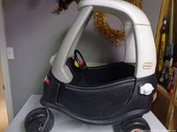 Side view of Little Tikes Cozy Coupe showing overall condition, wheels, roof, door and gas cap