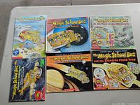 Six large-format Magic School Bus books laid out on table