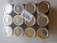Factory-wrapped tray of 12 jars showing metal lids