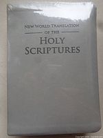 Front view of shrink-wrapped gray faux leather Bible showing title