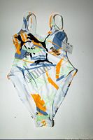 Front view of Puma abstract print one-piece swimsuit with tags attached
