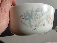 Side view showing pastel iris floral design on white opal glass bowl