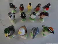 Front view of glazed porcelain bird figurines grouped in three rows