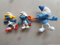 Three Smurfs PVC figurines displayed side by side