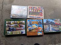 Five train puzzles displayed on floor