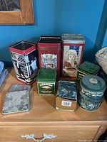 Group shot of all eight tins on dresser