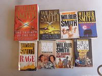 Eight Wilbur Smith paperbacks laid out in two rows