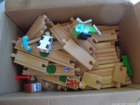 Box containing mixed wooden railway track, vehicles and figure