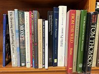 Shelf view of assorted art books including Picasso, Renoir, Bateman, Tom Thomson
