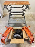 Workbench, pair of orange brackets, box containing saw and blade