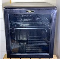 Front view of Danby Millennium wine cooler with glass door and interior racks