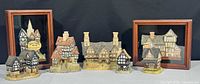 Group view of five free-standing cottages and two framed shadow boxes