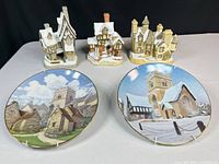 Group view of three village house figurines and two plates