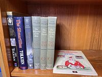All seven books on shelf showing spines