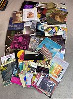 Overhead view of scattered vinyl albums showing variety of titles and sleeve art
