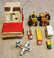 Group shot of all eight Tonka vehicles laid out on carpet