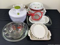 Full assortment showing salad spinner, measuring cups, baking dishes, tart dishes and strainers