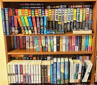 Full bookshelf view showing quantity and mix of J.D. Robb and Nora Roberts paperbacks