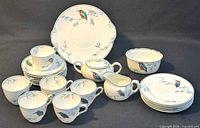 Full set of china showing cups, saucers, plates, sugar bowl with lid, creamer, serving bowl and platter