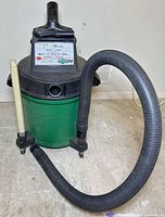 Full view of Sears Craftsman green/black wet-dry vacuum with hose and wand attached