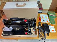 overall view of sewing machine in case with foot pedal, accessory box and extras
